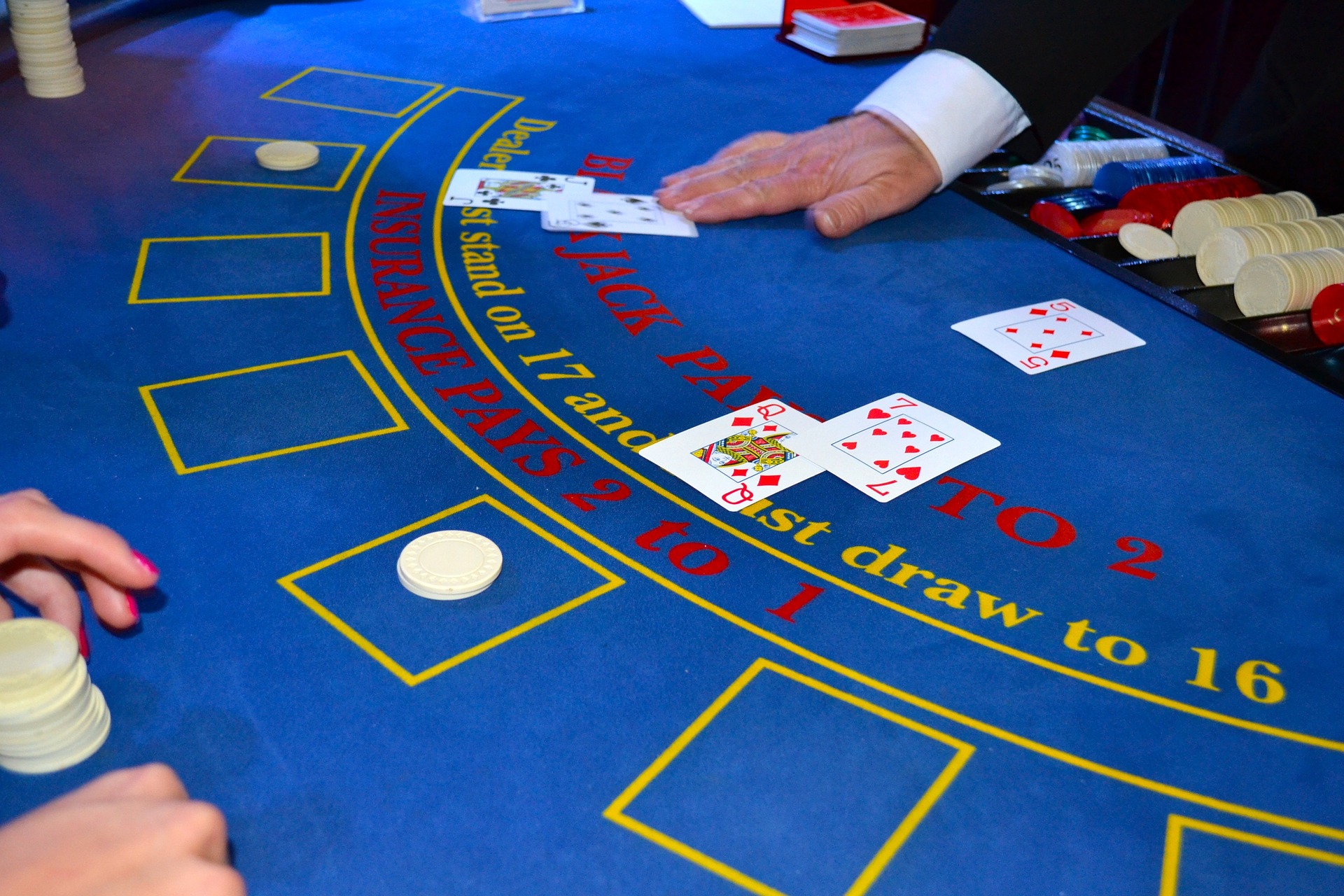 Situation de jeu à la table de blackjack au Casino avec croupier et joueur et cartes à jouer.